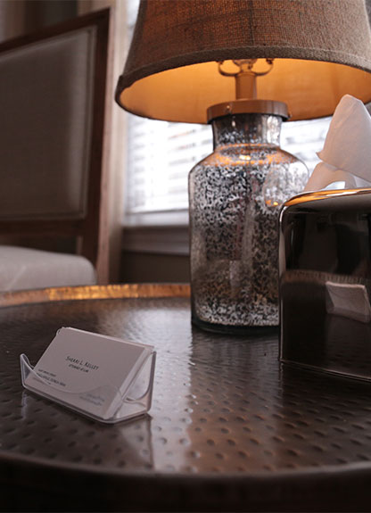 Business cards on a table with a lamp.